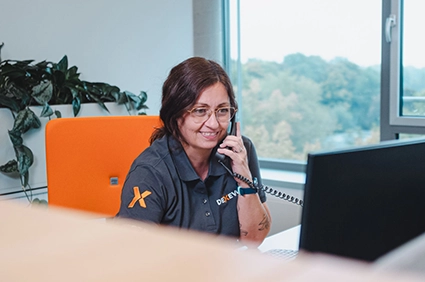 DEXEVO-Mitarbeiterin im telefonischen Kundengespräch am Arbeitsplatz